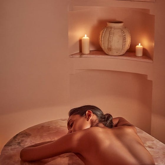 woman having treatment on pink onyx  bed