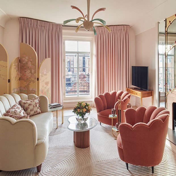 Romantic atmosphere, comfortable pink sofas and armchairs in an elegant interior design at Claridge's.