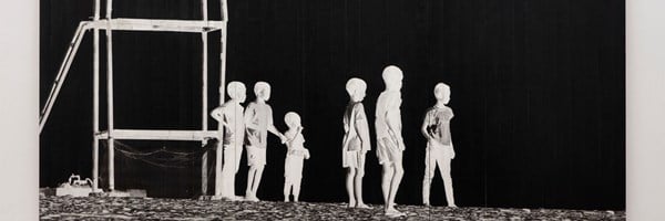 A monochrome artwork depicting a group of children standing in a row near a wooden lifeguard tower, their figures appearing as white silhouettes against a stark black background.