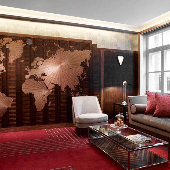 Red opulent Map Room, with comfortable sofas and armchairs and a map on the wall, perfect for relaxing and reading a book.
