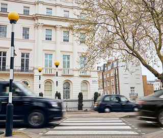 View of crossing and white residential buildings in London, with black taxis