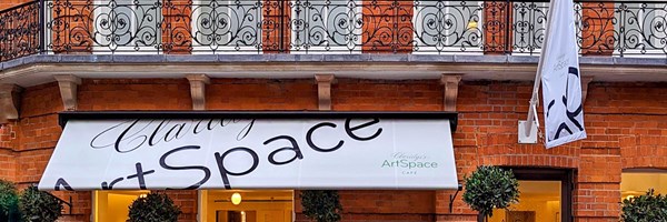 Exterior of Claridge's ArtSpace, white awning and red brick building.