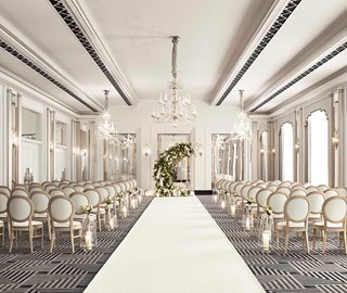 A wedding setting, with chairs and floral arrangements in a romantic art deco atmosphere in the Ballroom at Claridge's.