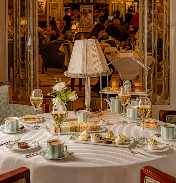 Elegant afternoon tea at Claridge’s, with fine pastries, finger sandwiches, and champagne in a refined setting.