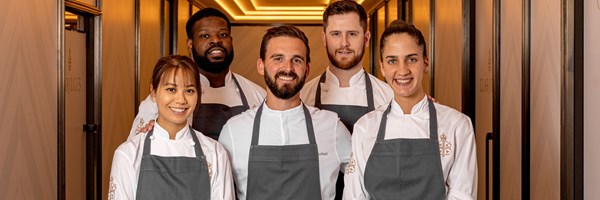 A group of chefs, elegantly posed in their crisp white uniforms, exuding the poise and precision behind Claridge's renowned culinary craftsmanship.