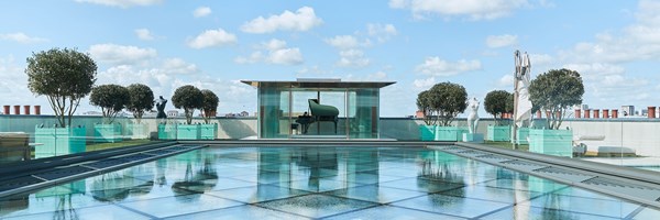 pavillion of penthouse with grand piano in the background overlooking a clear blue sky
